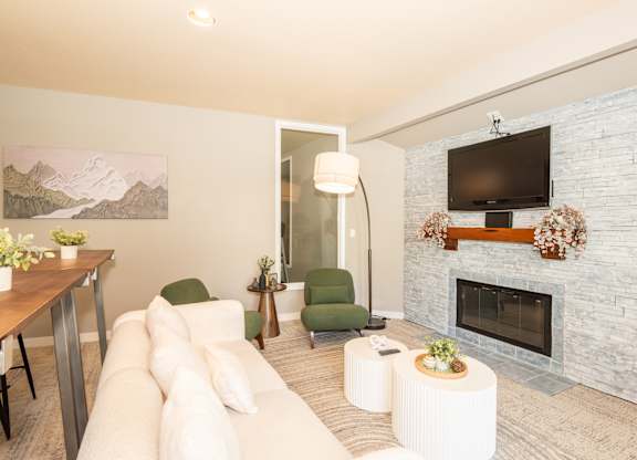 A living room with a fireplace and a painting of a mountain scene on the wall at Sunstone Parc, Beaverton, OR, 97008