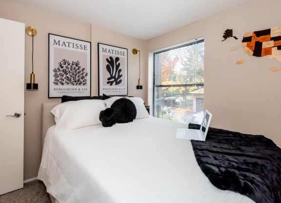 a bedroom with a large white bed and a window