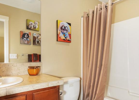 A white toilet sits in a bathroom next to a sink and a bathtub at The Landing Apartments and Townhomes, Oregon, 97045