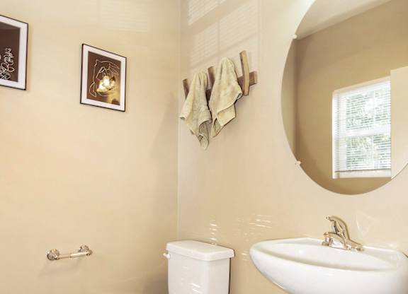 A white toilet and sink in a bathroom at The Landing Apartments and Townhomes, Oregon, 97045