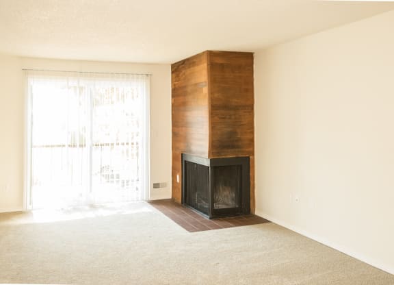 vacant apartment living room with a wood burning fireplace and a sliding glass door at Todd Village Apartments, Tualatin, OR