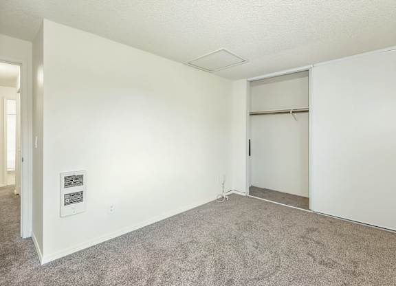 A room with a carpeted floor and a white door at Todd Village Apartments, Oregon, 97062