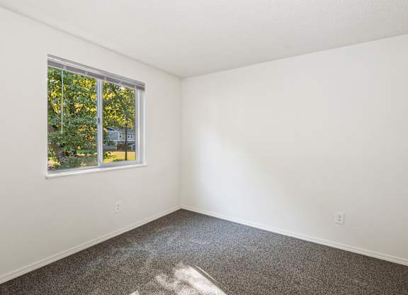A room with a window and a carpeted floor at Todd Village Apartments, Oregon, 97062