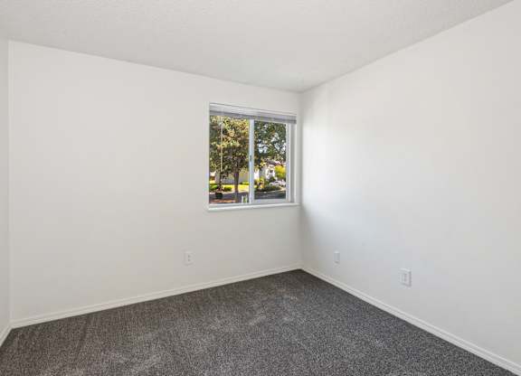 A room with a window showing a tree outside at Todd Village Apartments, Oregon, 97062