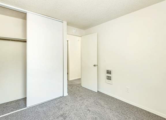 A white door is open to a carpeted hallway at Todd Village Apartments, Oregon, 97062