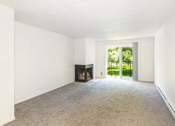 A room with a fireplace and carpeted floor at Todd Village Apartments, Oregon, 97062