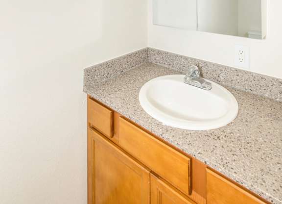 A bathroom with a sink, mirror, and light at Todd Village Apartments, Oregon, 97062