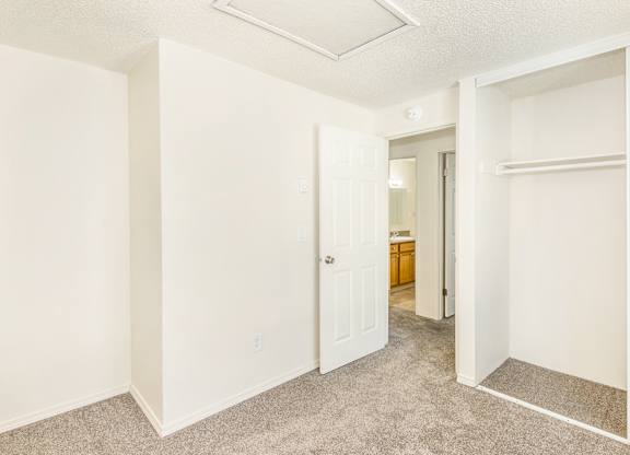 A white bedroom and open door to the hallway at Todd Village Apartments, Oregon, 97062