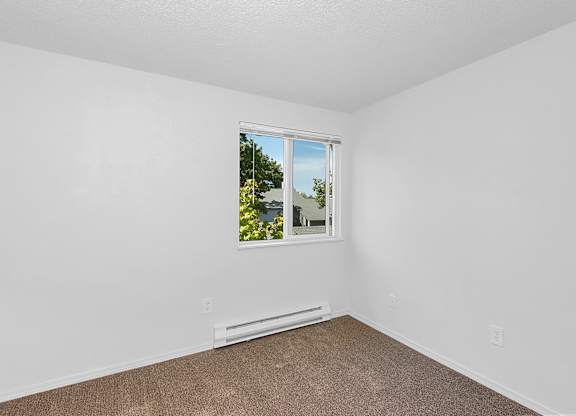 A room with a window and a carpeted floor at Todd Village Apartments, Oregon, 97062