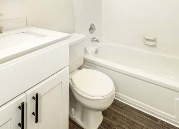 A white bathroom with a toilet, sink, and bathtub at Todd Village Apartments, Oregon, 97062