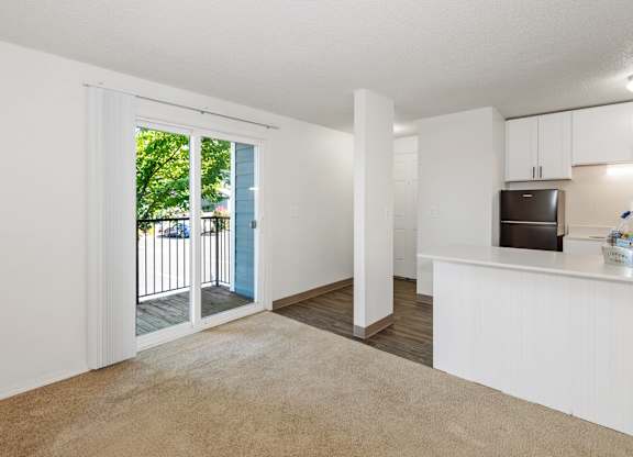 A kitchen with white cabinets and a black fridge at Todd Village Apartments, Oregon, 97062