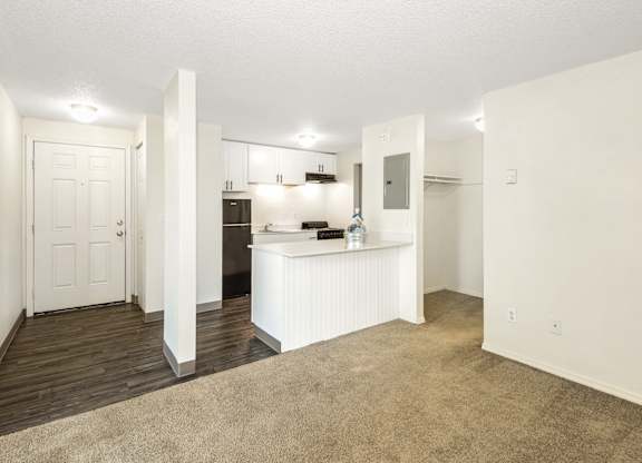 A white kitchen with a white door and white walls at Todd Village Apartments, Oregon, 97062