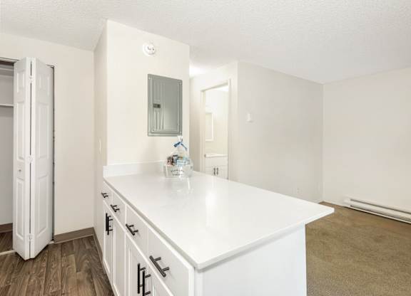 A kitchen with white cabinets and a white countertop at Todd Village Apartments, Oregon, 97062