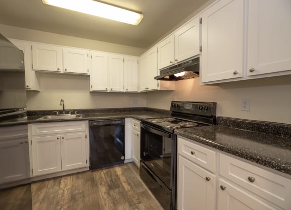 a kitchen with white cabinets and black appliances at Woodbridge Apartments, Sacramento, 95833