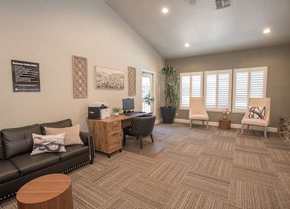 A business center with a black couch, a wooden coffee table, and a carpet on the floor at Zinfandel Village Apartments, California, 95670