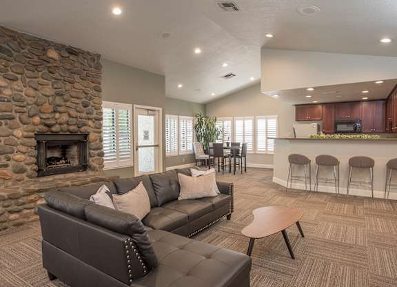 A clubhouse with a stone fireplace and a couch at Zinfandel Village Apartments, California, 95670