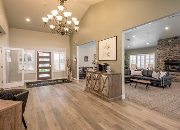 A foyer with a stone fireplace and a large painting on the wall at Zinfandel Village Apartments, California, 95670