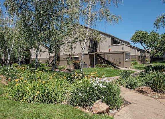 An apartment building with a green lawn in front of it at Zinfandel Village Apartments, California, 95670