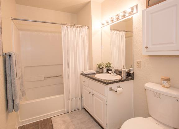 A white bathroom with a sink, toilet, and bathtub at Zinfandel Village Apartments, California, 95670