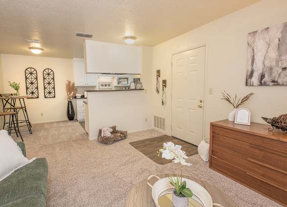 A living room with a green couch and a white wall at Zinfandel Village Apartments, California, 95670
