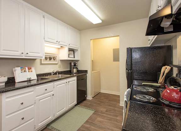 A kitchen with white cabinets and a black stove top at Zinfandel Village Apartments, California, 95670