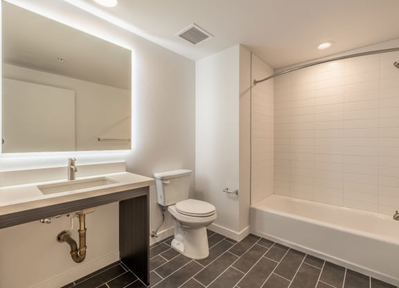 a bathroom with a toilet sink and tub and a mirror