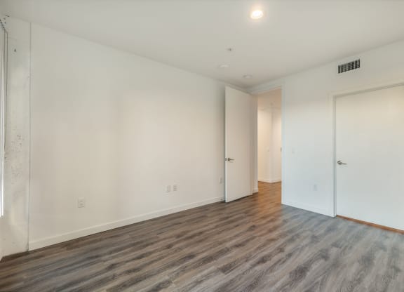 a living room with white walls and wood floors