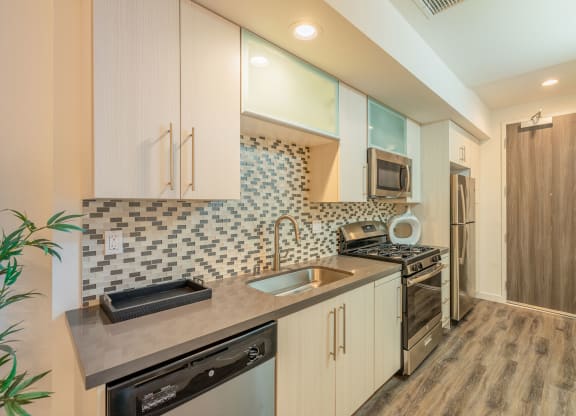 a kitchen with white cabinets and a sink and a stove