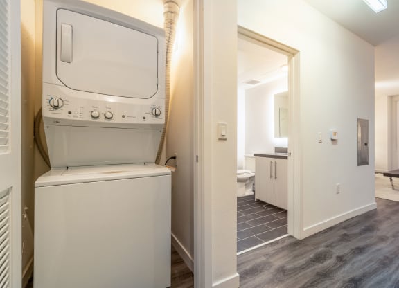 a laundry room with a washer and dryer and a door to a bathroom