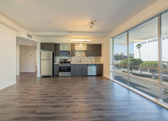 a kitchen with a large window and a stainless steel refrigerator