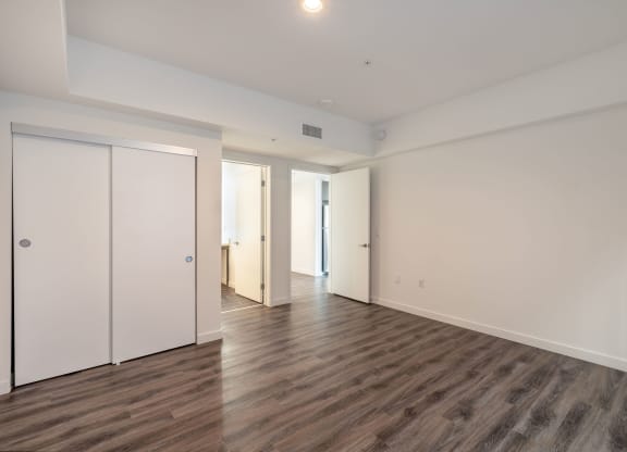 an empty living room with white walls and wood flooring