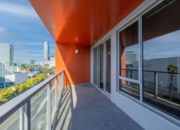 a balcony with a view of a city and a glass door