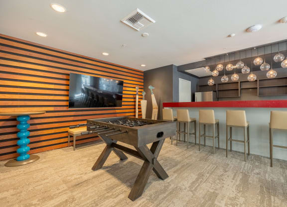 a game room with a foosball table and a bar