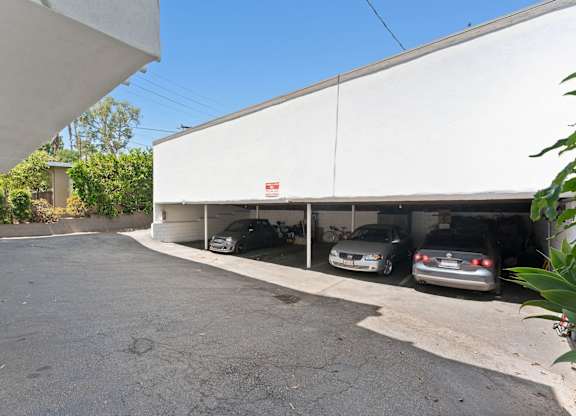 Two cars are parked in a white garage.