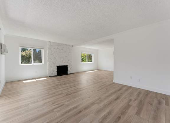 A room with wooden flooring and white walls.