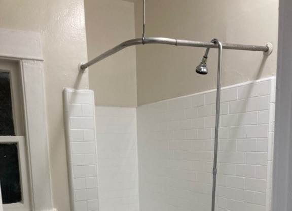 Bathroom with white tile and fixtures at The Western at Rosewood in Los Angeles, California.