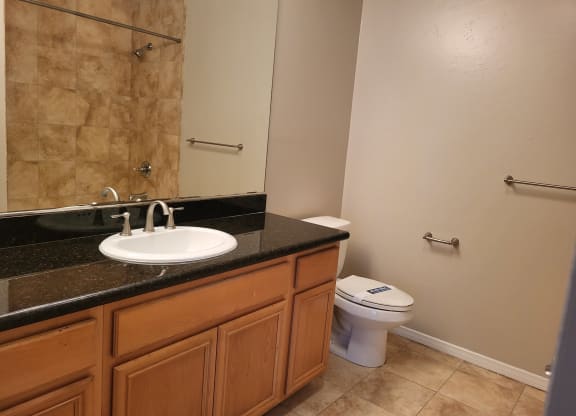 Master bedroom bathroom with granite countertop and tile flooring at The Cove at Bear Valley in Escondido, California.