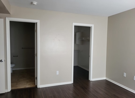 Master bedroom with bathroom, large walk-in closet and plank style flooring at The Cove at Bear Valley in Escondido, California.