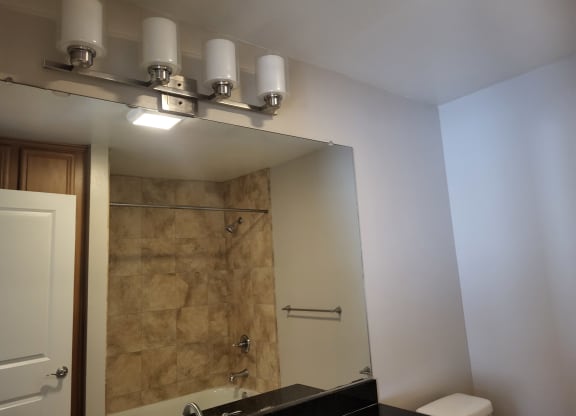 Bathroom with beautiful tile bath, large mirror and closets at The Cove at Bear Valley in Escondido, California.