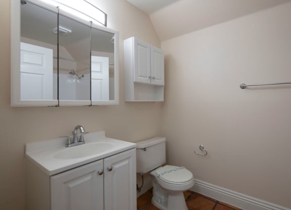 Bathroom with white fixtures and Saltillo flooring at the Atrium Apartments in San Diego, California.