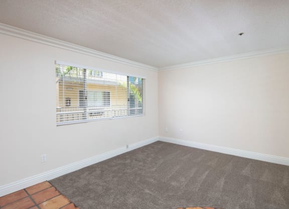 Front room with custom blinds over large window at the Atrium Apartments in San Diego, California.