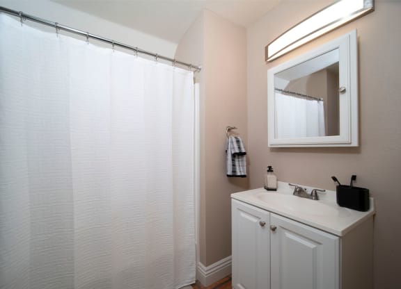 Model unit bathroom with white fixtures at the Atrium Apartments in San Diego, California.