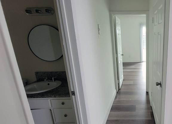 A bathroom with a sink and mirror is visible.