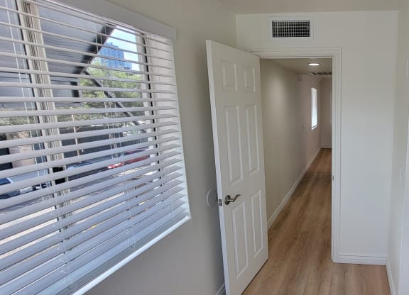 Bedroom with mirrored closet doors and lots of natural light in one bedroom apartment at the Atrium Apartments in San Diego, CA.