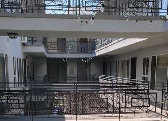 A courtyard with a metal railing and a planter box.