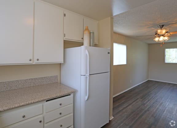 Open kitchen with white cabinets and appliances at Villa Pacific Apartments in Oceanside, California.
