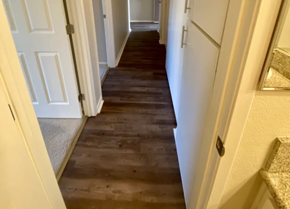 Looking from bathroom down bedroom hallway with built-in cabinets at Villa Pacific Apartments in Oceanside, California.