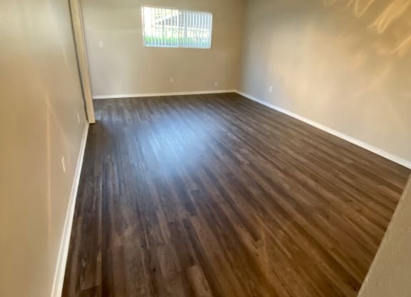 Plank style flooring in living room and dining area with ceiling fan at Villa Pacific Apartments in Oceanside, California.