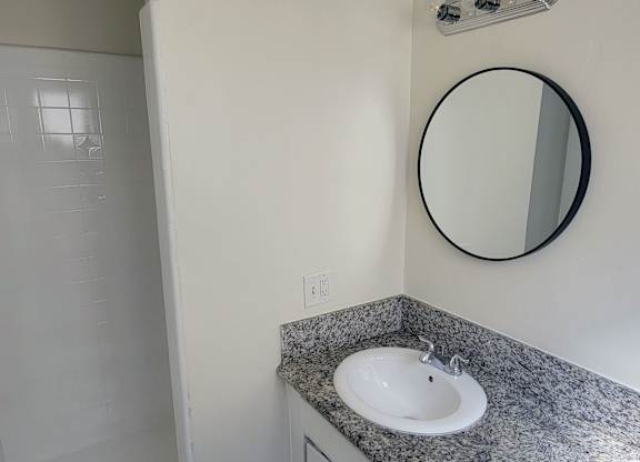 A bathroom with a sink and mirror.