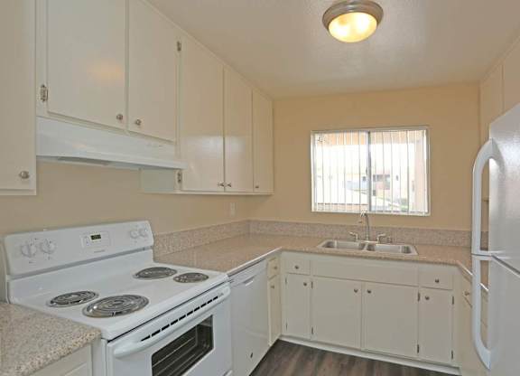 A kitchen with white appliances and cabinets.